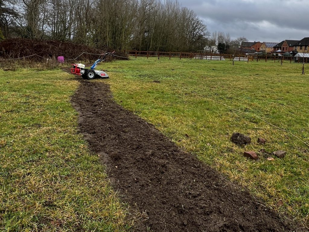 a rotovator tilling the line where the hedge will be planted